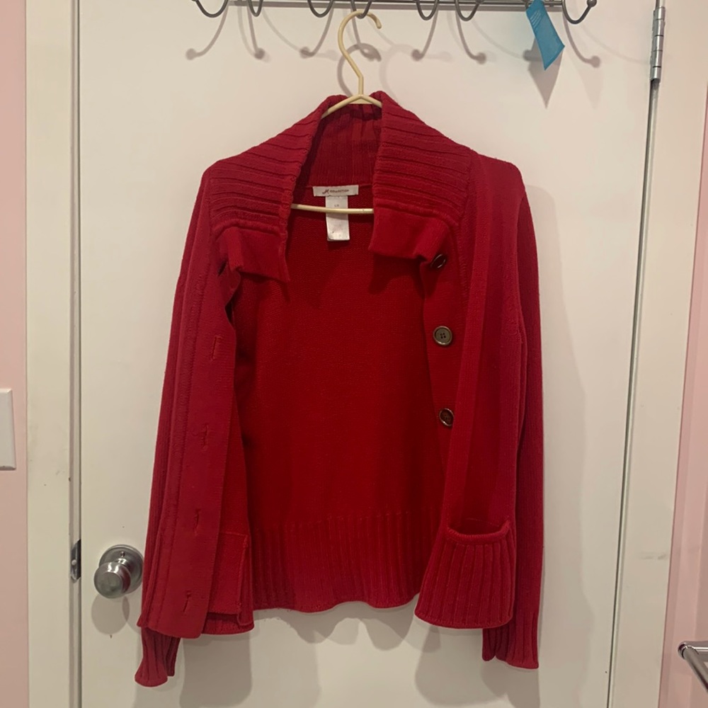 A red sweater in good condition. No tearing or holes, just slightly worn out.